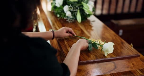 Coffin, λουλούδι και τα χέρια της γυναίκας στην κηδεία για αντίο με θλίψη, απώλεια ή πόνο του πένθους closeup. Λυπηρό, θάνατος και αυξήθηκε για το σεβασμό με τη σύζυγο στην εκκλησία για την τελετή αποχαιρετισμού ή επιμνημόσυνη δέηση. - Πλάνα, βίντεο