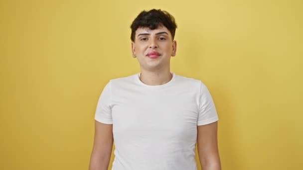 Joy-filled young man, confident and successful, celebrating achievement, beaming a winning smile! standing isolated, wearing a white t-shirt against a vibrant yellow background. - Footage, Video