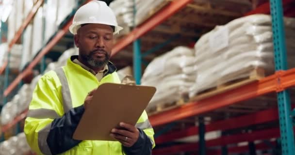 Walking, warehouse and black man with clipboard for inspection, inventory and check stock. Shipping, distribution and person writing checklist for logistics, maintenance and manufacturing in factory. - Footage, Video