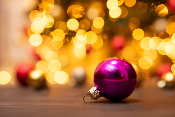 Purple ball Christmas tree decoration on wooden background. Celebrating Christmas copy space holiday background, festive winter mood - Photo, Image