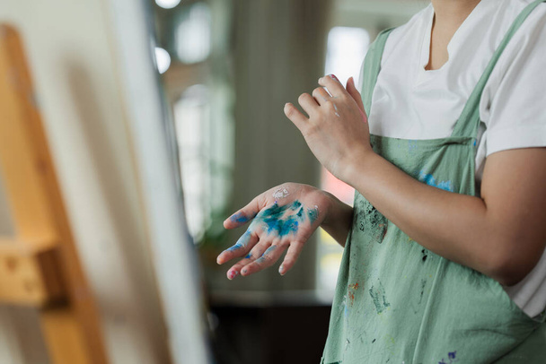 Krásná mladá žena umělec pracuje na malování něco na velké plátno. - Fotografie, Obrázek