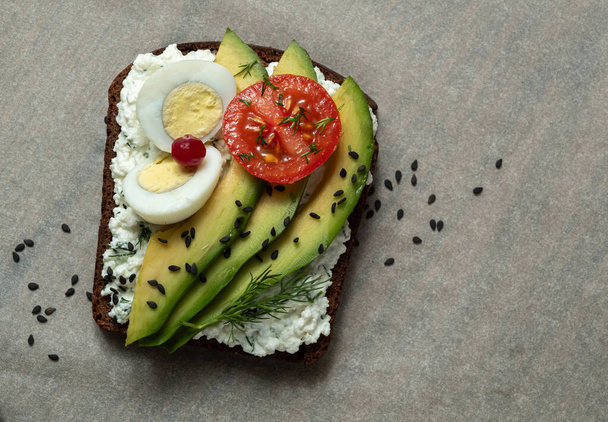 Healthy toast with cottage cheese, avocado, egg and tomato. Ahealthy snacking - Photo, Image