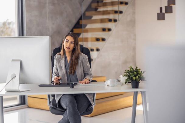Empresária confiante trabalhando em laptop em seu local de trabalho no escritório moderno. Conceito de negócios, pessoas e tecnologia. - Foto, Imagem