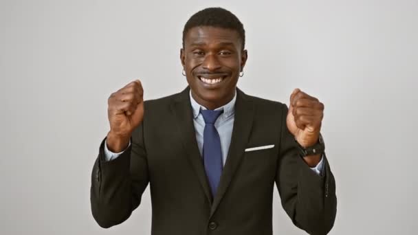 Eksztatikus afro-amerikai férfi öltönyben, feltartott karokkal és örömmel. izgatott üzleti győztes ünnepli győzelem elszigetelt fehér háttér - Felvétel, videó