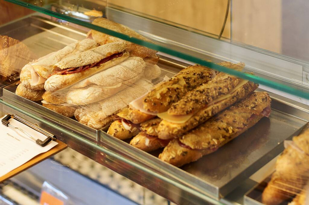Аппетитные ремесленные бутерброды, готовые к продаже в витрине деликатесов. - Фото, изображение