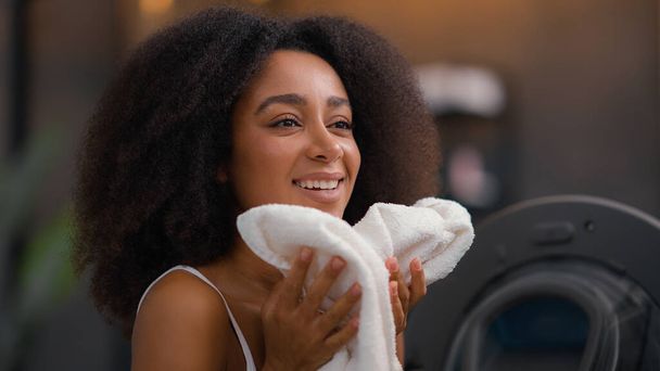 afro-américaine fille ethnique dame biraciale femme au foyer travail à la maison routine bonne odeur blanchisserie vêtements ouvert machine à laver ménage ménage odeur tissu propre parfum conditionneur - Photo, image