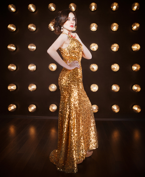 Supertähti nainen yllään kultainen paistaa mekko
  - Valokuva, kuva