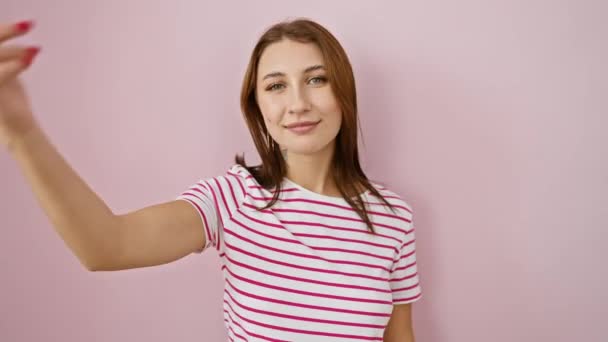 Веселая юная брюнетка в полосах футболка указывая пальцем на голову на розовом изолированном фоне, уверенная улыбка излучает отличную идею или память - Кадры, видео