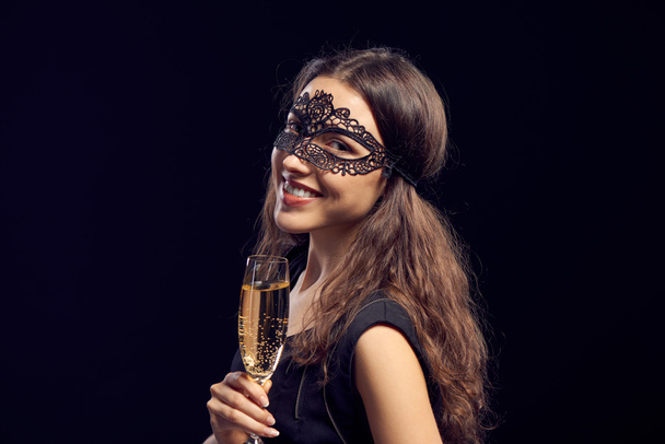 Happe woman in mask holding glass with champagne - 写真・画像