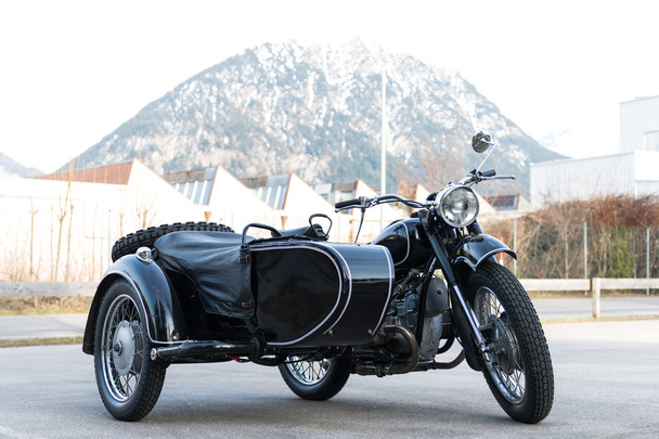 Oude zwarte oldtimer motorfiets met aanhangwagen kant auto - Foto, afbeelding