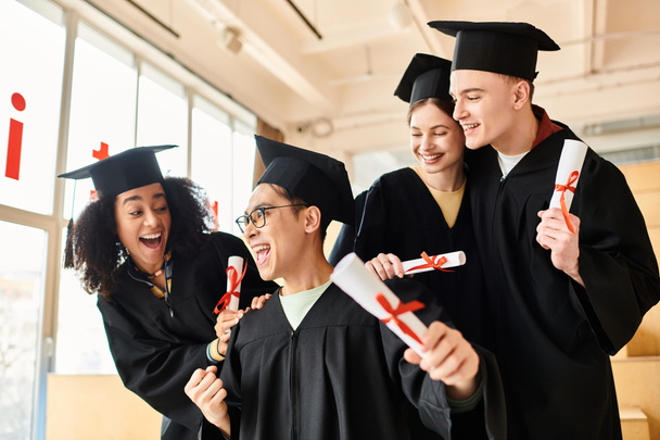 Eine bunte Gruppe von Menschen im Abschlussgewand, die Diplome in der Hand halten und ihre akademischen Leistungen mit einem Lächeln feiern. - Foto, Bild