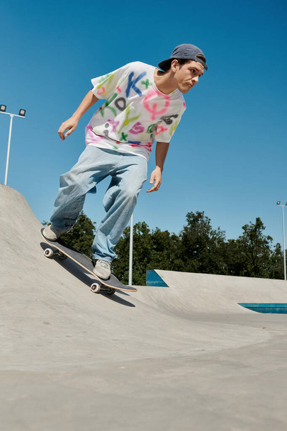 A young skater boy fearlessly rides his skateboard down the side of a ramp in a skate park on a sunny summer day. - Photo, Image