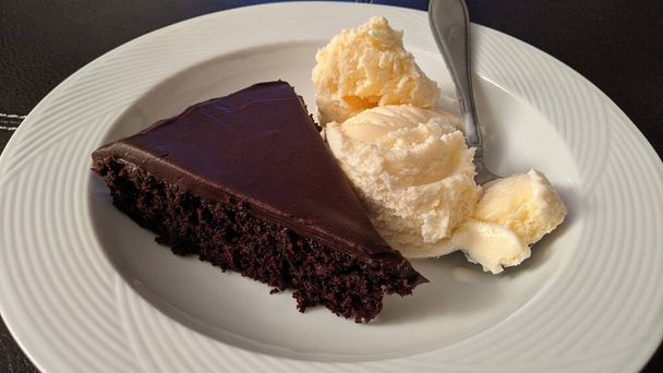 インディアナ州フォートウェインでの豪華な朝食 - ホワイトプレート上のバニラアイスクリームと豊富なチョコレートケーキのスライス,2021 - 写真・画像