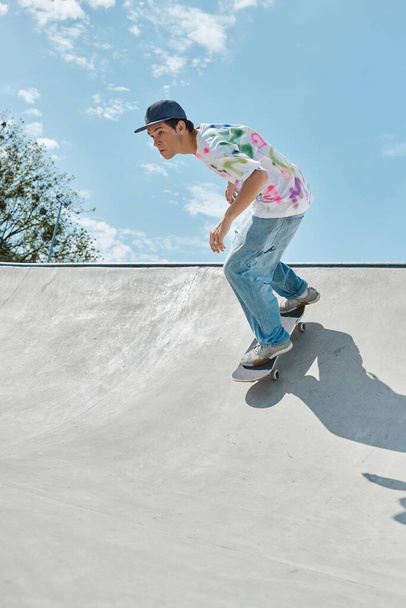 Сміливий молодий ковзаняр їде скейтборд вгору по стороні пандуса в сонячному відкритому скейт-парку в літній день. - Фото, зображення