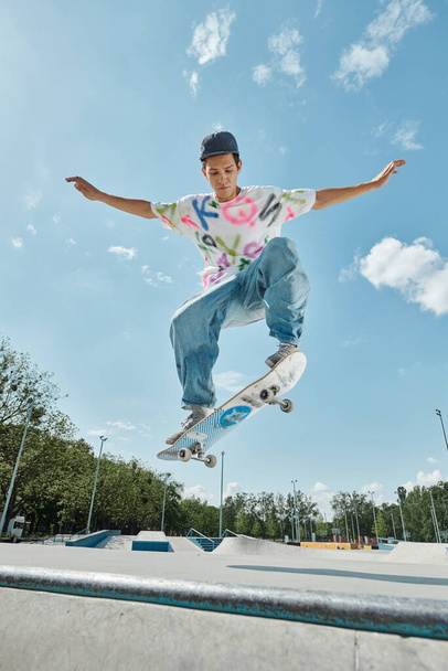 Ein junger Mann führt in einem sonnigen Outdoor-Skatepark einen beeindruckenden Midair-Trick auf einem Skateboard vor. - Foto, Bild