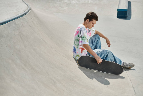 Młody człowiek w głębokiej koncentracji siedzi na deskorolce i szybuje przez żywy skatepark w słoneczny letni dzień.. - Zdjęcie, obraz