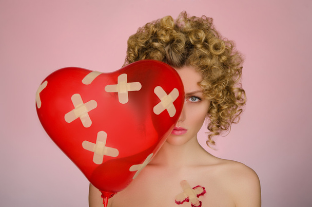 Upset woman with patches on the body and balloon - Foto, imagen