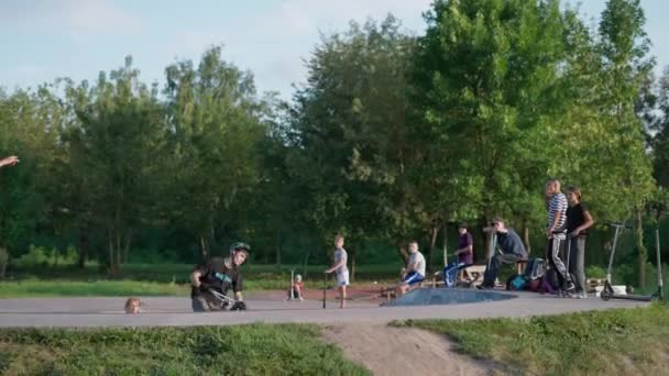 BMX rider wykonuje trik w powietrzu z publicznością w parku. - Materiał filmowy, wideo