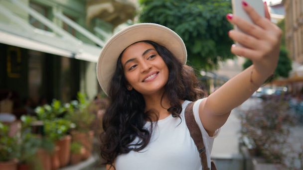 Happy souriant Indien Arabe ethnique femme fille étudiant touriste voyageur influenceur prendre selfie photo téléphone portable caméra ville à l'extérieur voyager vlog stream médias sociaux vidéo vacances - Photo, image