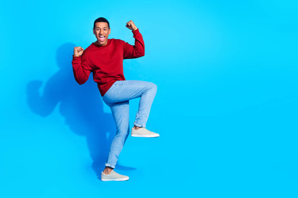 Full body profile portrait of delighted cheerful person raise fists success empty space isolated on blue color background. - Foto, Imagem