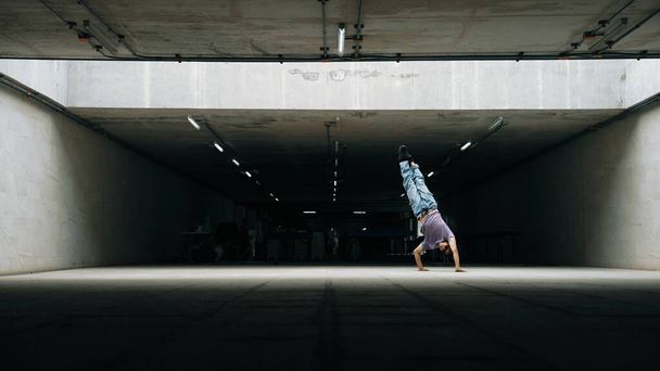 Ομάδα ελκυστικών Ασιατών χίπστερ χορευτών διαλείμματος στο κτίριο. Κομψή χορεύτρια φορώντας κομψό ύφασμα, ενώ κάνει στάση κατάψυξης. Ελεύθερος χορός και ενεργητικός χορός. Υπαίθριο άθλημα 2024. Ελαφρώς. - Φωτογραφία, εικόνα