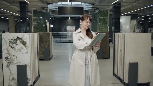 Γυναίκα με tablet σε εκθετήριο πλακιδίων - Πλάνα, βίντεο
