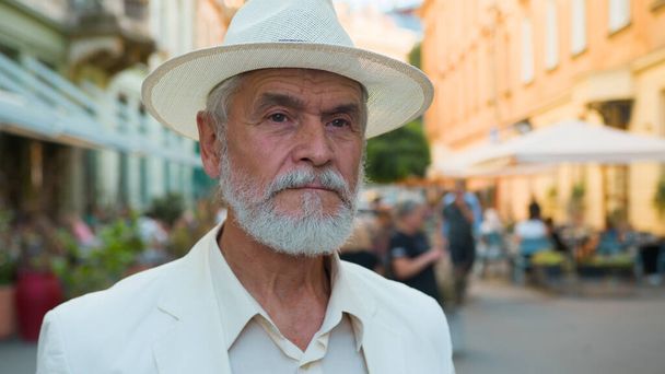 Lähikuva rauhallinen vanha vanhempi 60-vuotias kypsä harmaa tukka kaukasialainen tyylikäs mies eläkkeellä liikemies älykäs mies turisti näköinen kamera kaupungin ulkopuolella katu vanhempi muotokuva potilaan terveyspalvelu - Valokuva, kuva