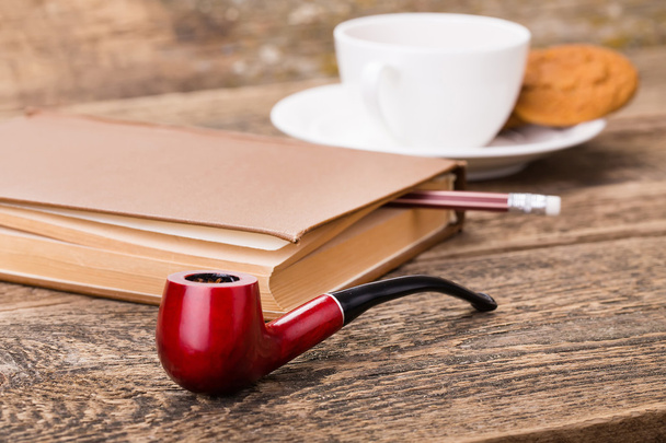 Tobacco pipe for smoking, ivory tea cup with sweet cookie, and b - Foto, Bild