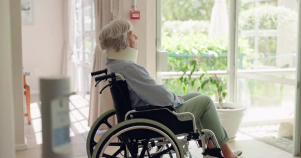 Senior, woman and neck brace in wheelchair for injury with thinking, reflection on accident and relax by window. Elderly, patient and thoughtful in hospital for rehabilitation, healthcare or healing. - Footage, Video