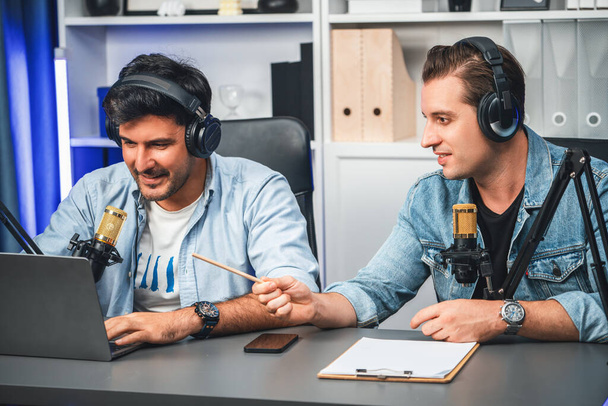 Host channel of creative broadcaster living by smartphone in positive podcast with special guest in list script to advice listeners, wearing headsets, using mic radio record at studio. Sellable. - Foto, afbeelding