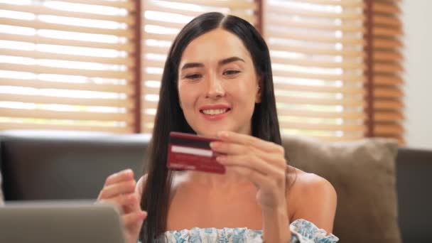 Молодая женщина, использующая ноутбук с кредитной картой для интернет-банкинга, интернет-магазинов электронной коммерции через интернет оплаты шлюз на дому. Современные и удобные онлайн покупки с дебетовой картой. Блайт - Кадры, видео