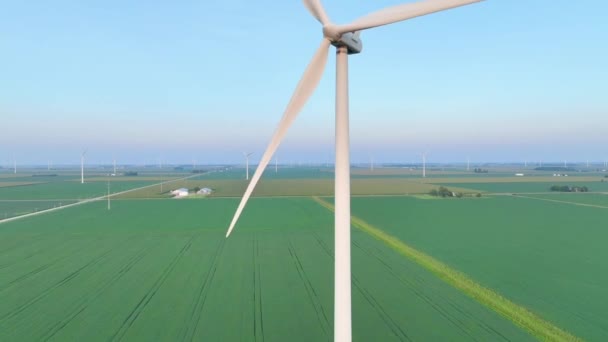 Aerial Pedestal Shot of Wind Turbines on Ohios Country Farmland, showcasing the grandeur of renewable energy within serene agricultural landscapes in the tranquility of early morning or late - Footage, Video