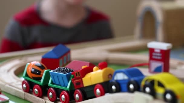 boy plays with a toy train and cars - Imágenes, Vídeo