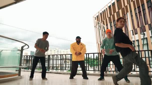 Ryhmä hipsteriä siirtymässä hip-hop-musiikkiin käytävällä. Taitava break tanssija suorittaa b-poika tanssi kun ympäröi monikulttuurinen ystävä tai tanssiryhmä. Ulkona urheilu 2024 hip hop. - Materiaali, video
