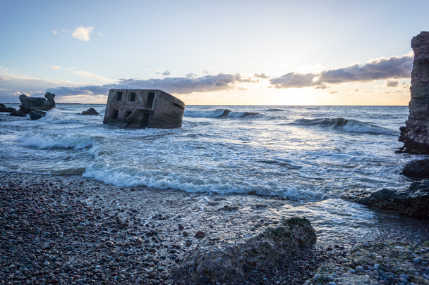 aallot murskaavat kiviä auringonlaskussa
 - Valokuva, kuva