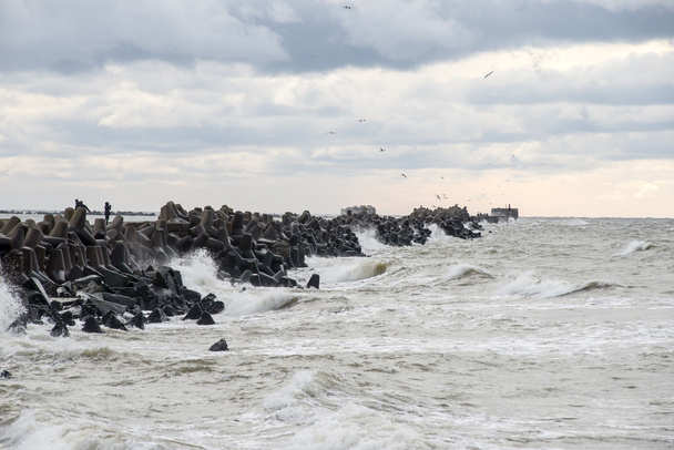 Волны, давящие скалы на закате
 - Фото, изображение