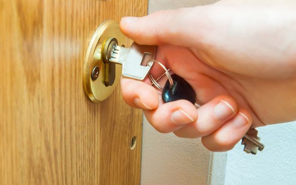 Locking up or unlocking door with key in hand - Foto, imagen