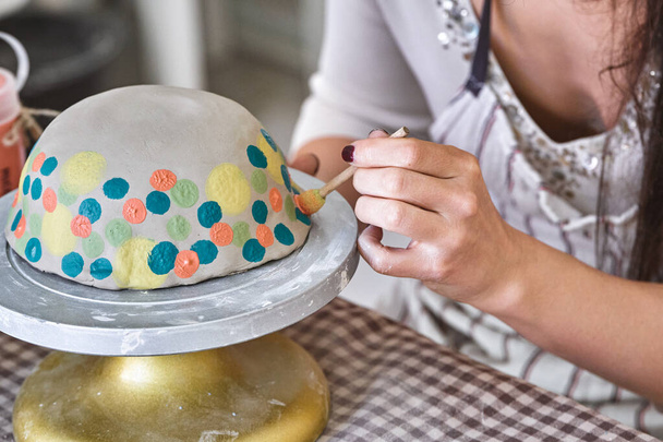 Artista aplica vibrantes lunares a un tazón de cerámica en un tocadiscos, mostrando intrincados detalles de la mano - Foto, imagen