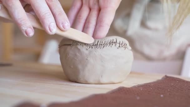 Řemeslník nanáší texturu na hliněnou misku s dřevěným žebrem.  - Záběry, video