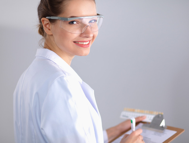 Attractive female dentist with tools , standing on gay background - Φωτογραφία, εικόνα