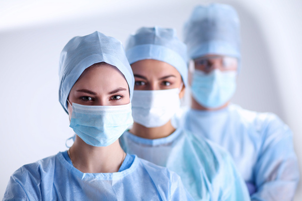 Surgeons team, wearing protective uniforms,caps and masks - Foto, Imagem