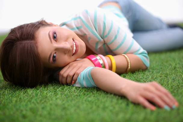 Beautiful young woman lying on green grass - Photo, image