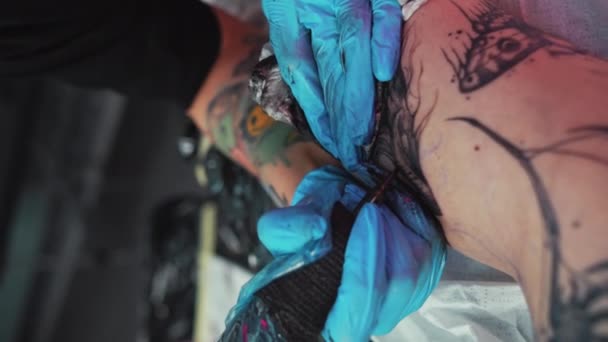 Mani di primo piano di un maestro del tatuaggio che fa un tatuaggio sulla gamba delle ragazze - Processo di tatuaggio. Filmati 4k di alta qualità - Filmati, video