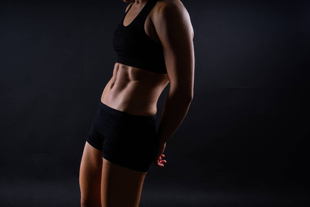 Γυμναστική γυναίκα δείχνει κοιλιακούς επίπεδη κοιλιά, απομονωμένη. Αθλητική γυναικείο σχήμα κοιλιακό - Φωτογραφία, εικόνα