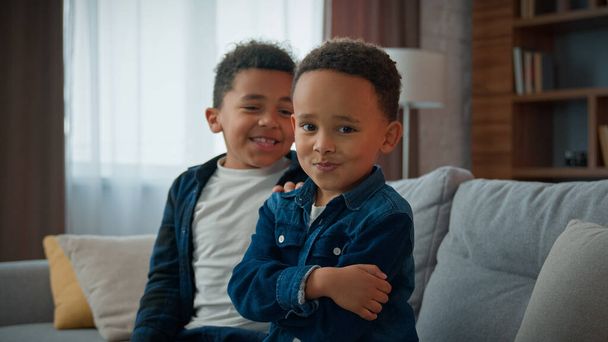 Two funny African American children siblings after quarrel at home funny boy kid pretend offended ignoring joking pretending frustrated sad ignore brother sorry apologize make peace calming friend - Photo, Image