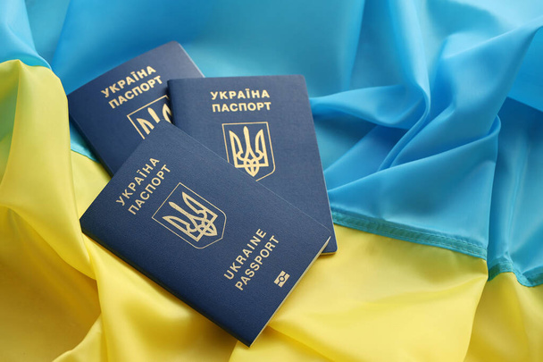 Trzy ukraińskie paszporty biometryczne na składanej fladze kraju Ukraina zbliżyć - Zdjęcie, obraz