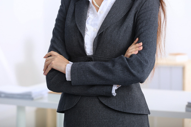 Portrait of business woman standing with crossed arms in office - Photo, image