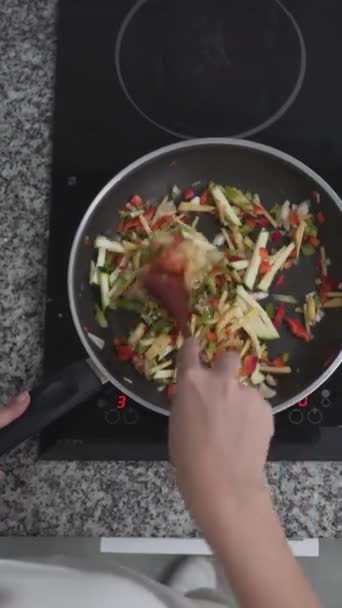 Top View Of A személy főzés egészséges vegetáriánus étkezés segítségével elektromos tűzhely. Általános költségek - Függőleges - Felvétel, videó