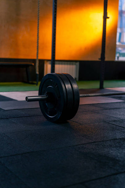 close-up in a sports club of athletic plates on a barbell for on a bright orange background - Photo, Image