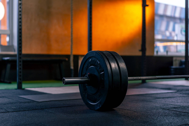 close-up in a sports club of athletic plates on a barbell for on a bright orange background - Photo, Image
